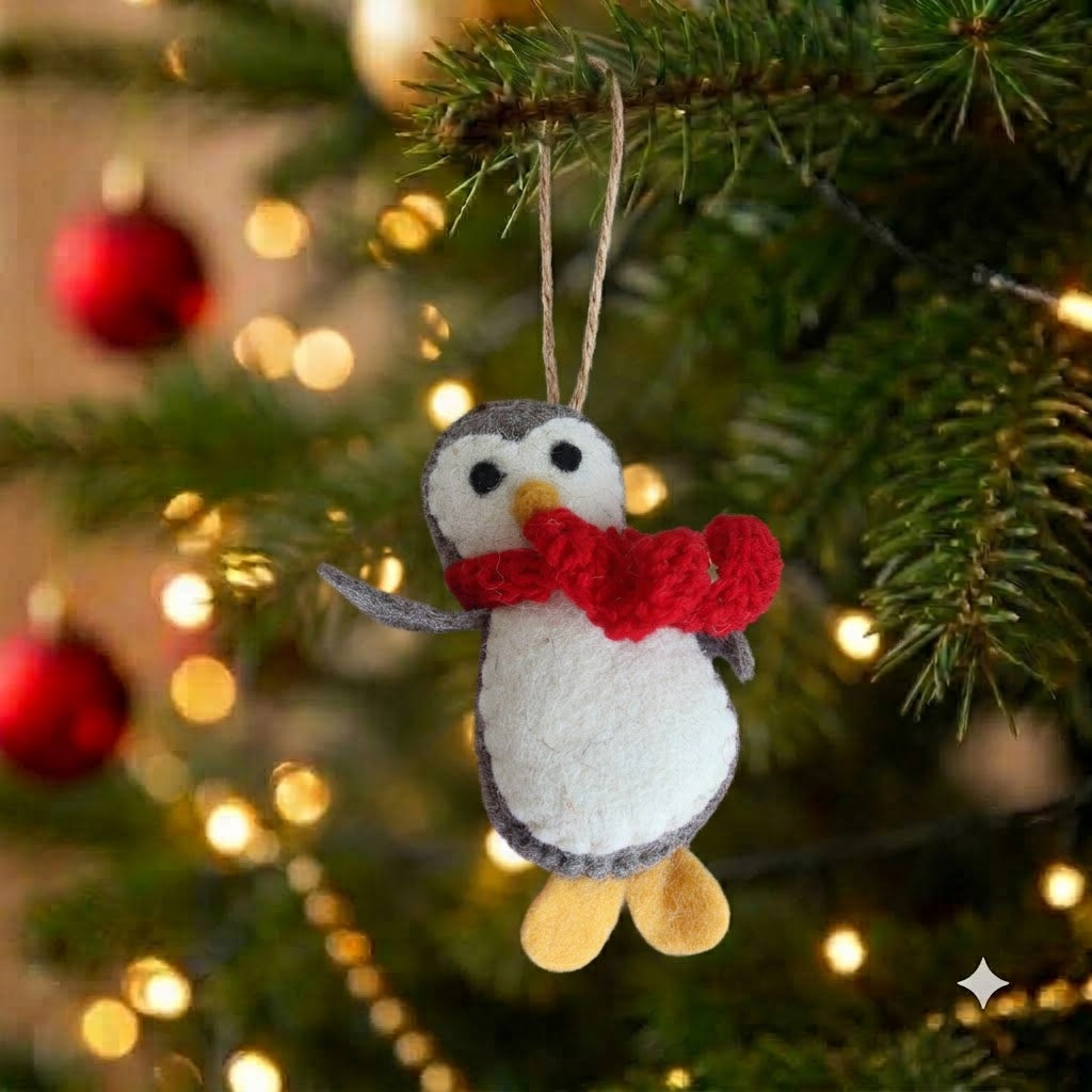 Ms. Fluffles felt penguin Christmas ornament with red scarf hanging on a Christmas tree