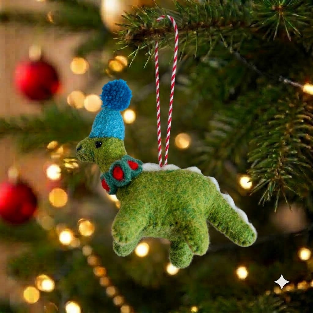 Doodly the Dino green felt dinosaur Christmas ornament in a blue bobble hat on a Christmas tree