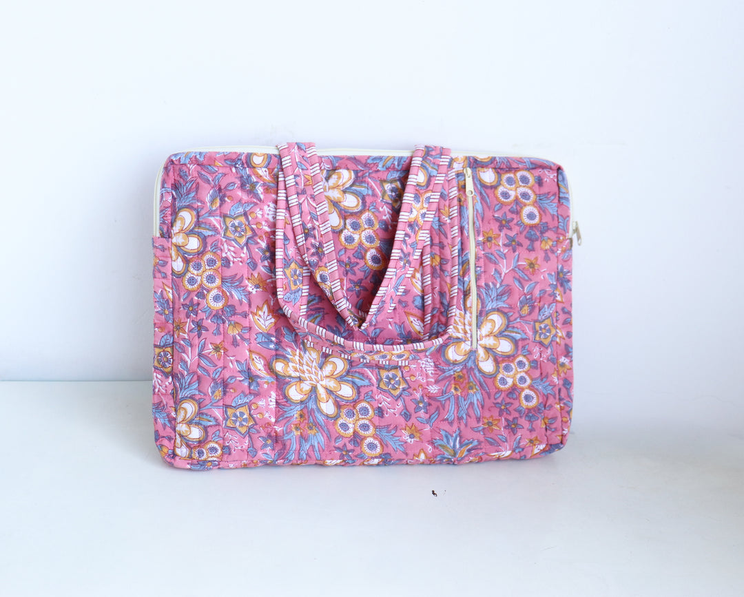 Block print laptop bag in pink floral showing side zip pockets and double handles