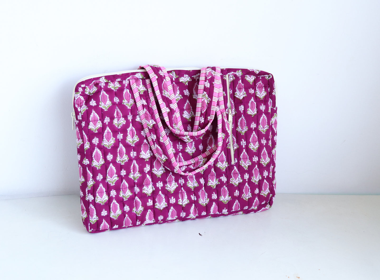 Magenta booti laptop bag open view showing padded interior and side zip pockets