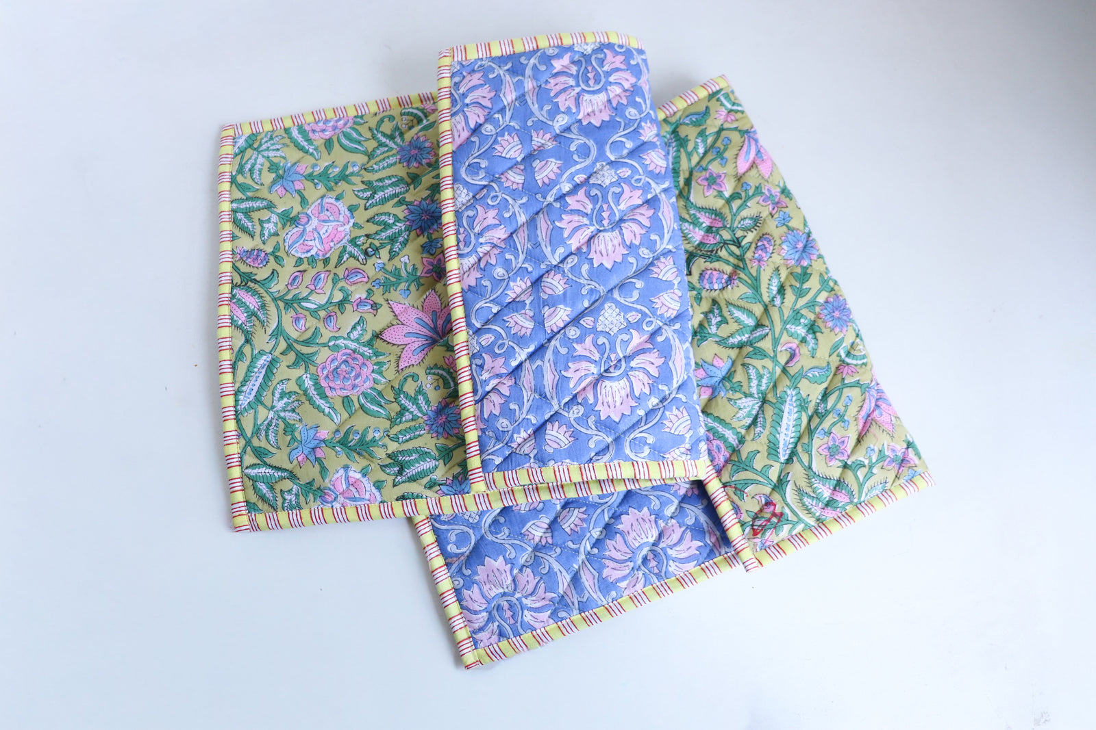 Close-up of lime green block print quilted placemat showing handmade quilted texture and foam-padded construction