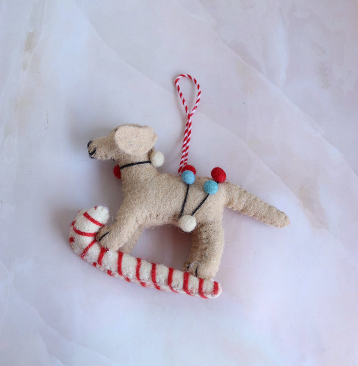 Bruno on Skis handmade felt Labrador ornament on red-and-white striped skis, front view