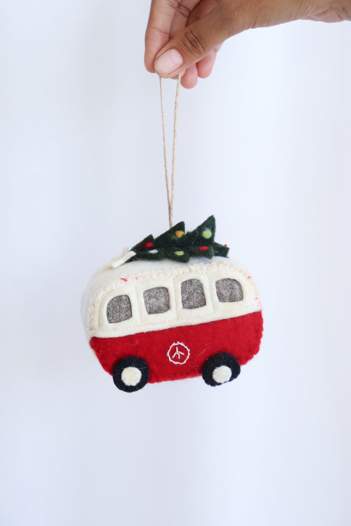The Christmas Campervan handmade felt ornament held up by its loop, front view