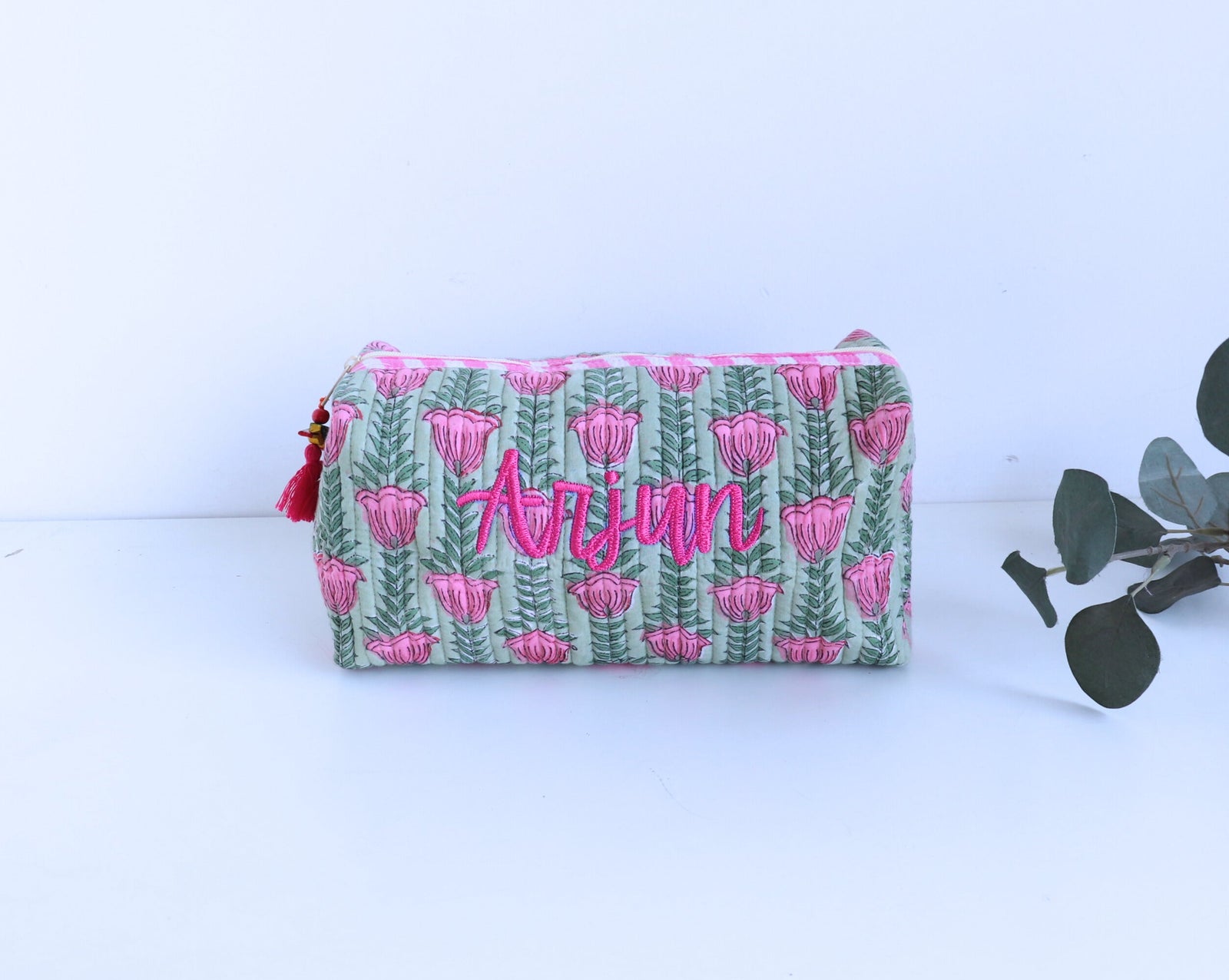 Large pouch with pink floral pattern and 'Arjun' text on a green background