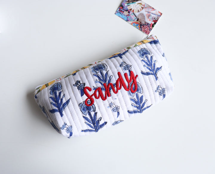Quilted block print pencil pouch in blue floral print with hand-embroidered custom name, zip closure