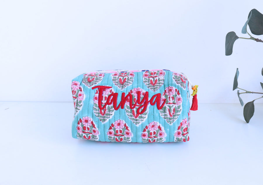 Floral-patterned pouch with 'Tanya' text on a light blue background